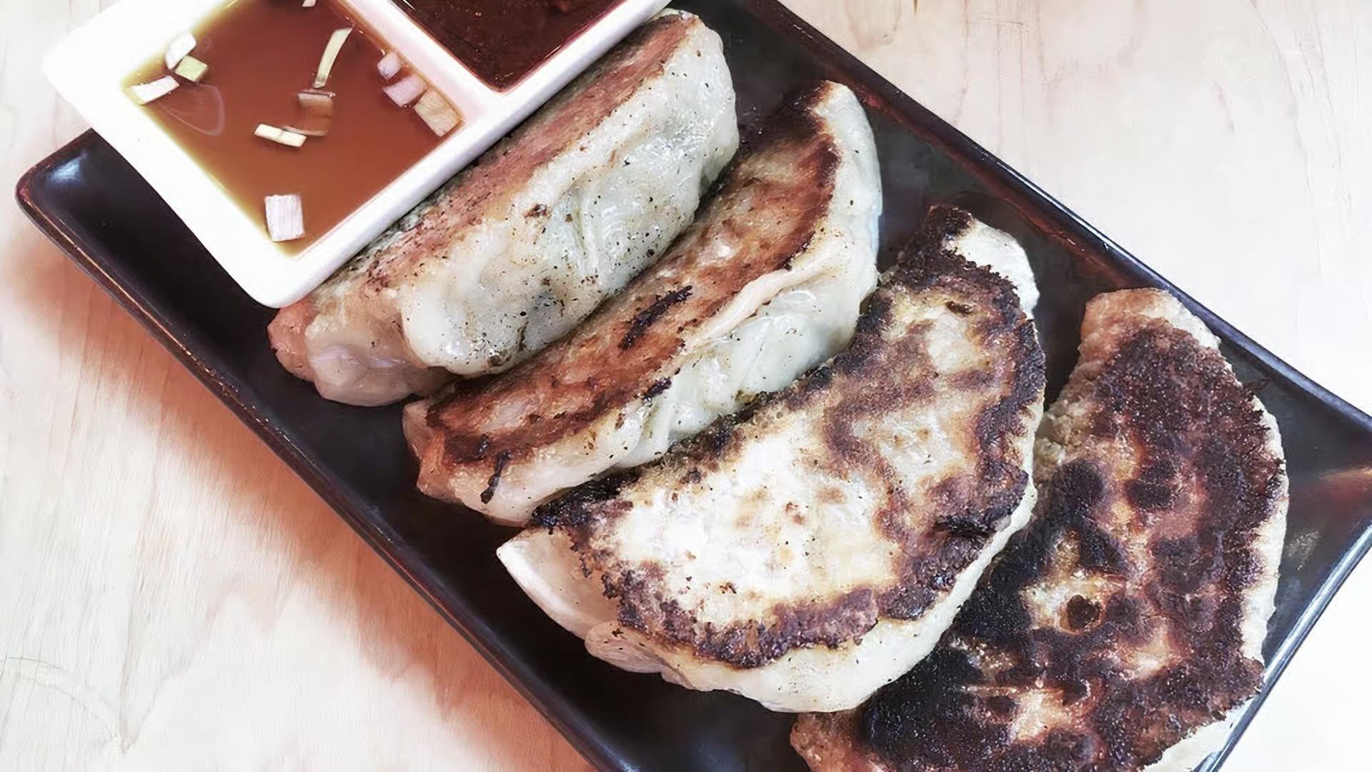 Crispy fried gyoza dumplings with dipping sauce at Karakatta Ramen